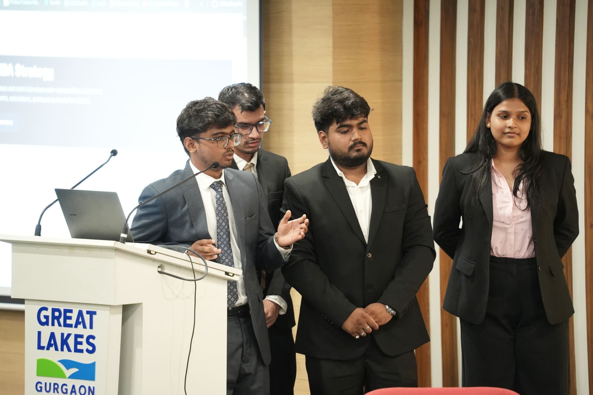 A student team presenting together at the podium during the AI Mini Hackathon final