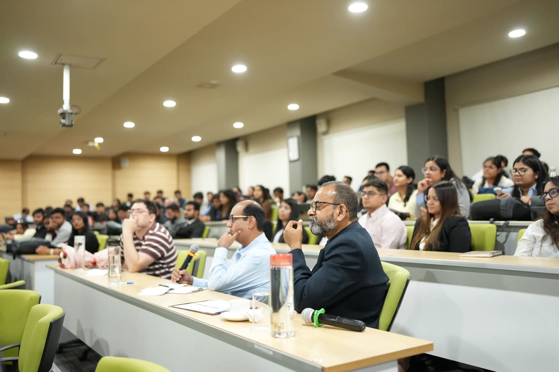 A hackathon jury and audience reviewing teams in a live presentation room