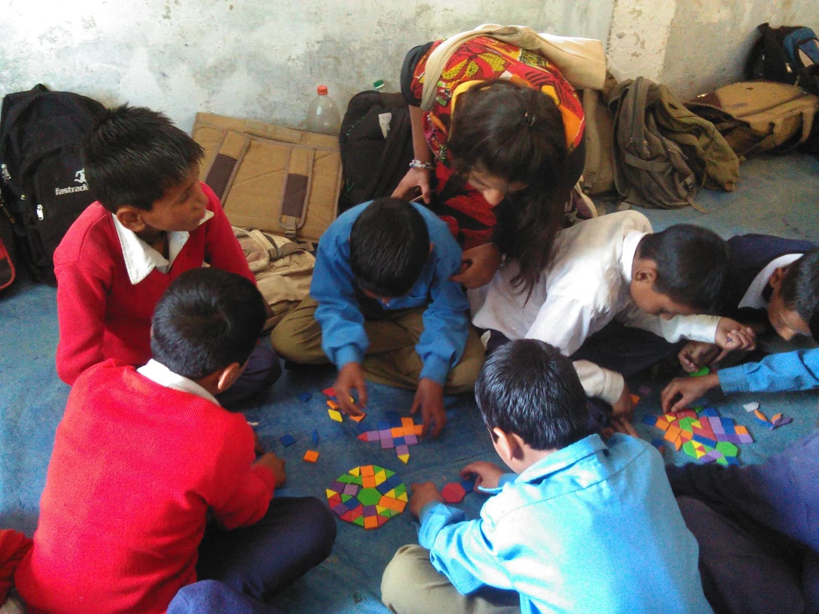 Schoolchildren gathered around a pattern-block geometry activity with a facilitator