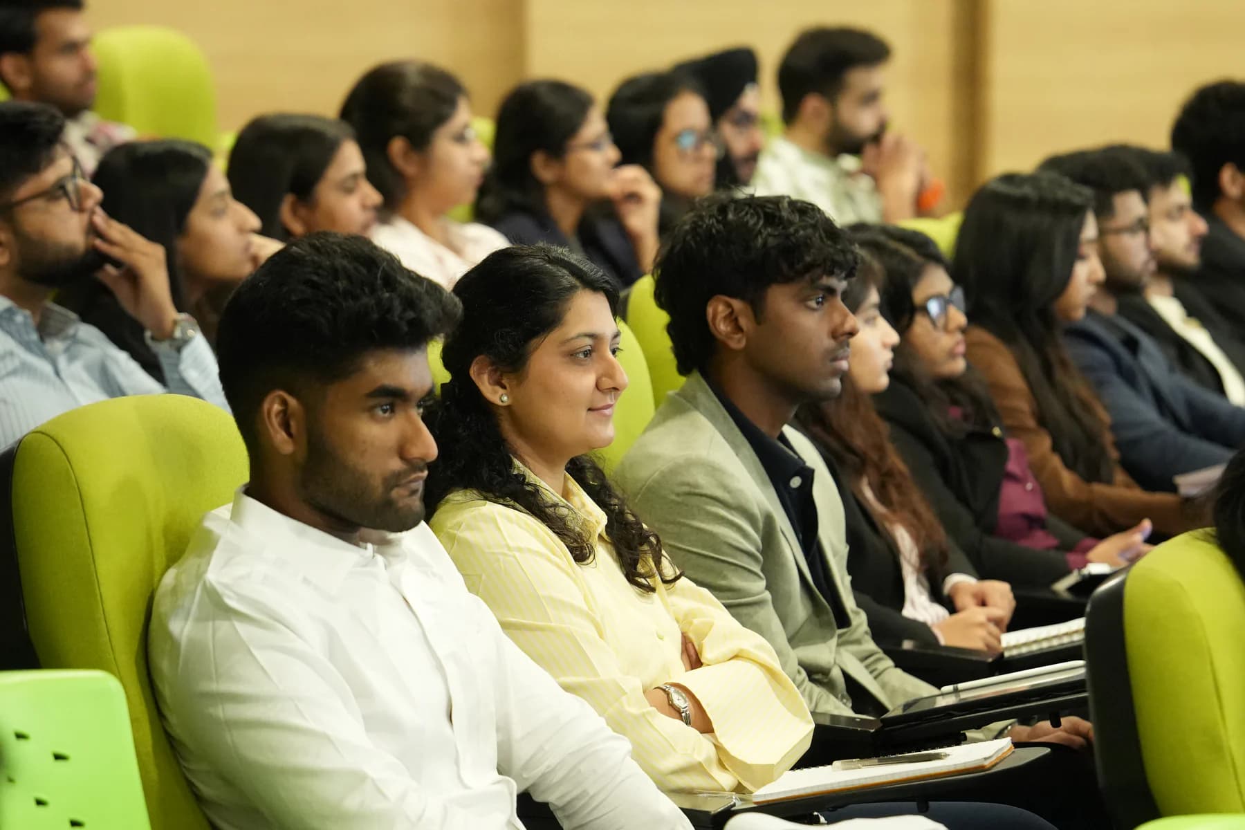 A two-year management cohort listening closely during a live classroom exchange