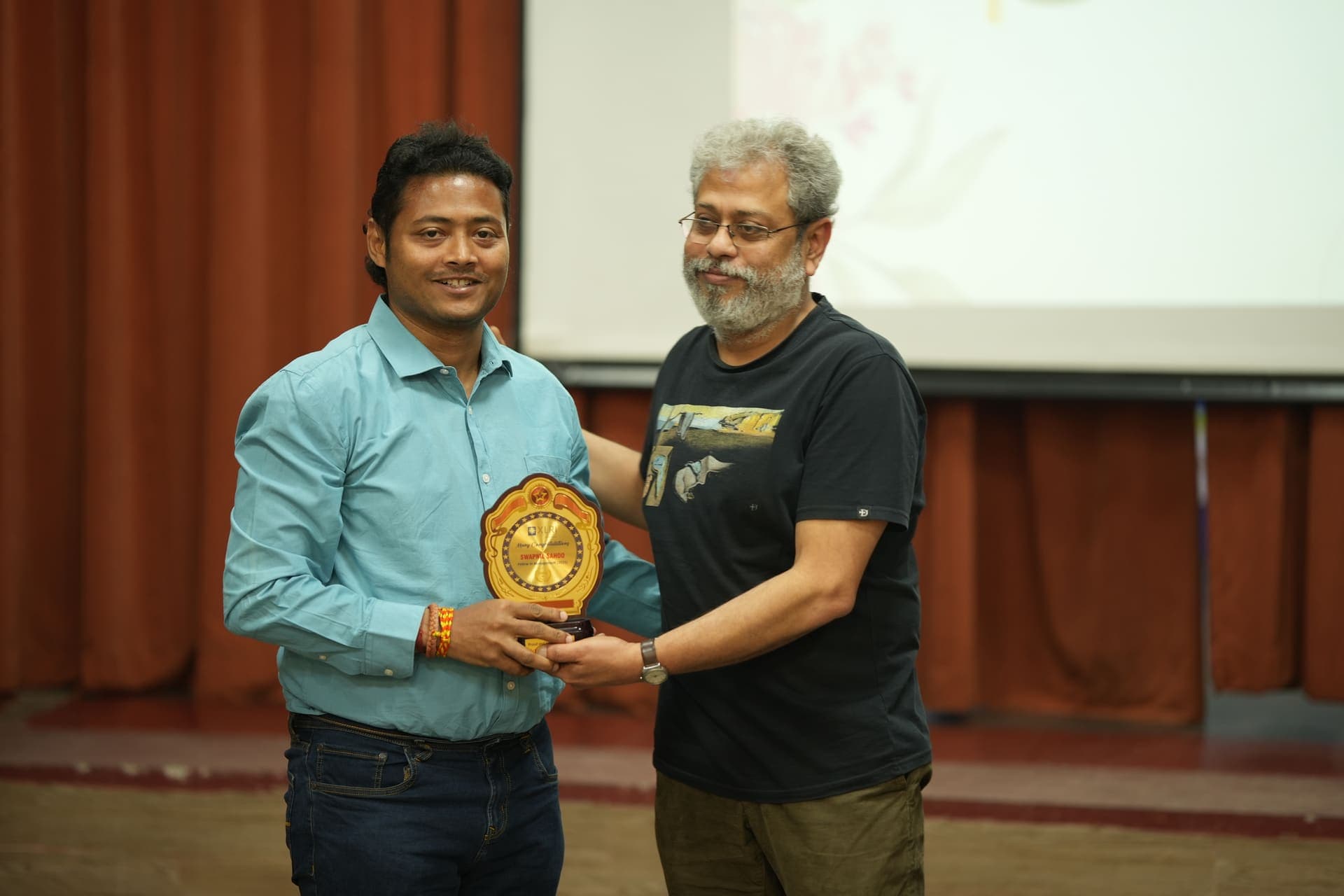 Dr Swapnil Sahoo receiving a Fellow in Management memento from a senior faculty member at XLRI's Doctoral Au Revoir 2025