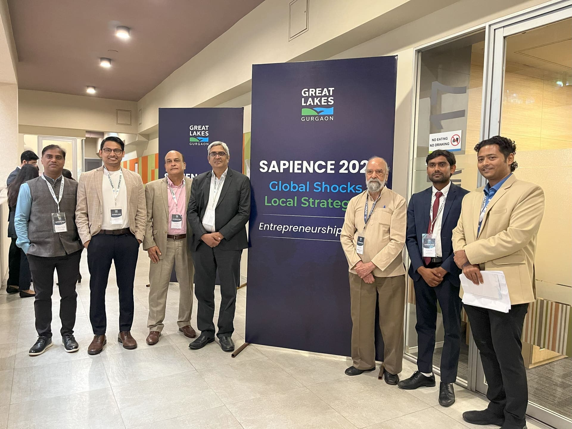 Dr Swapnil Sahoo and fellow panellists beside the SAPIENCE 2025 'Global Shocks, Local Strategies' banner at Great Lakes Gurgaon