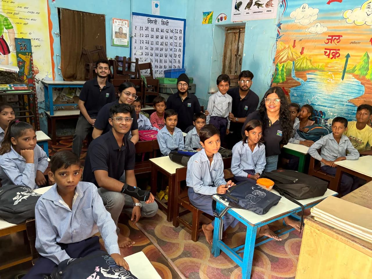Management students and schoolchildren gathered together inside a classroom
