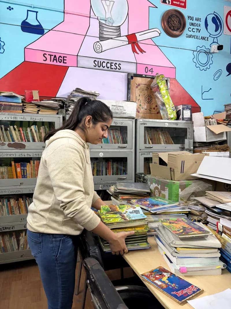 A management student sorting children's books in a school library