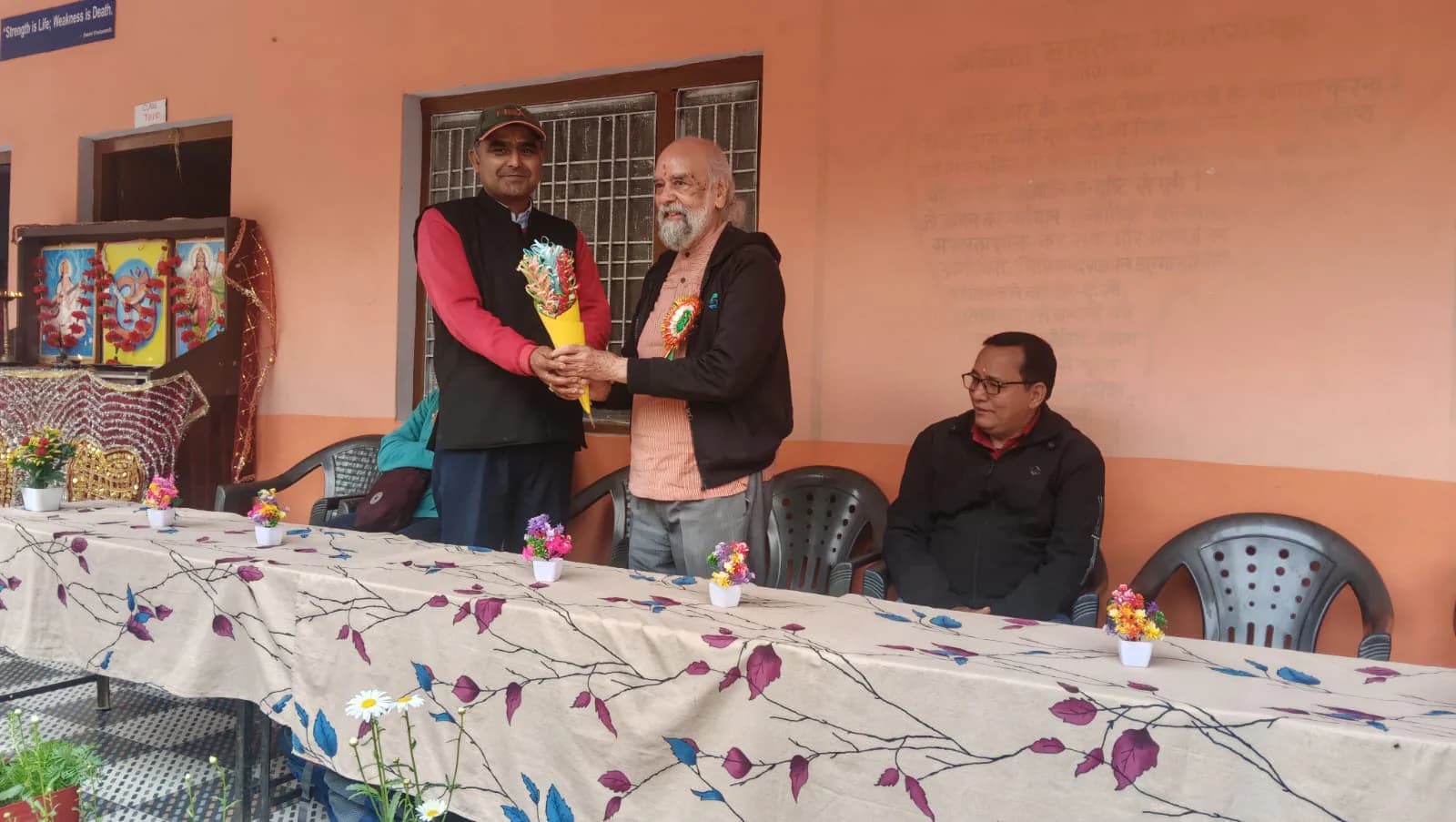 Prof. S. K. Palhan exchanging a bouquet with a local school representative