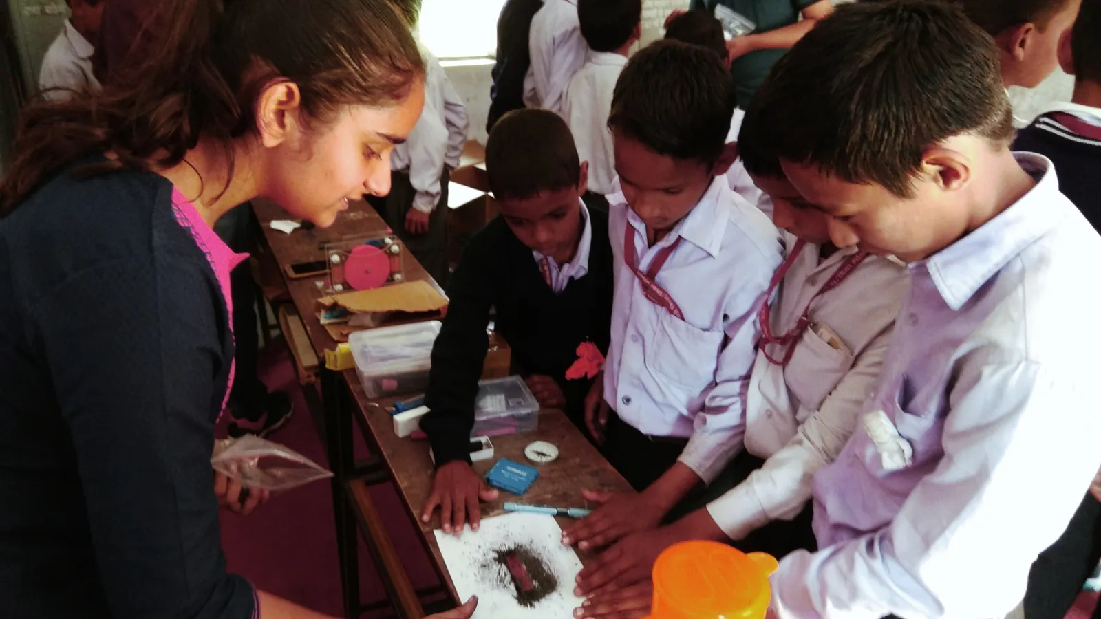 A facilitator guiding schoolchildren through a hands-on science activity